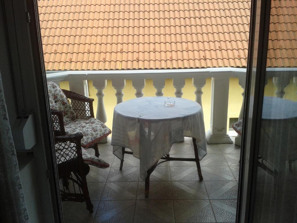 哈卡尼Ilda Apartments的阳台配有桌椅和白色的桌布
