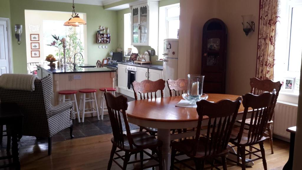 格伦蒂斯Brook Lodge的厨房以及带木桌和椅子的用餐室。