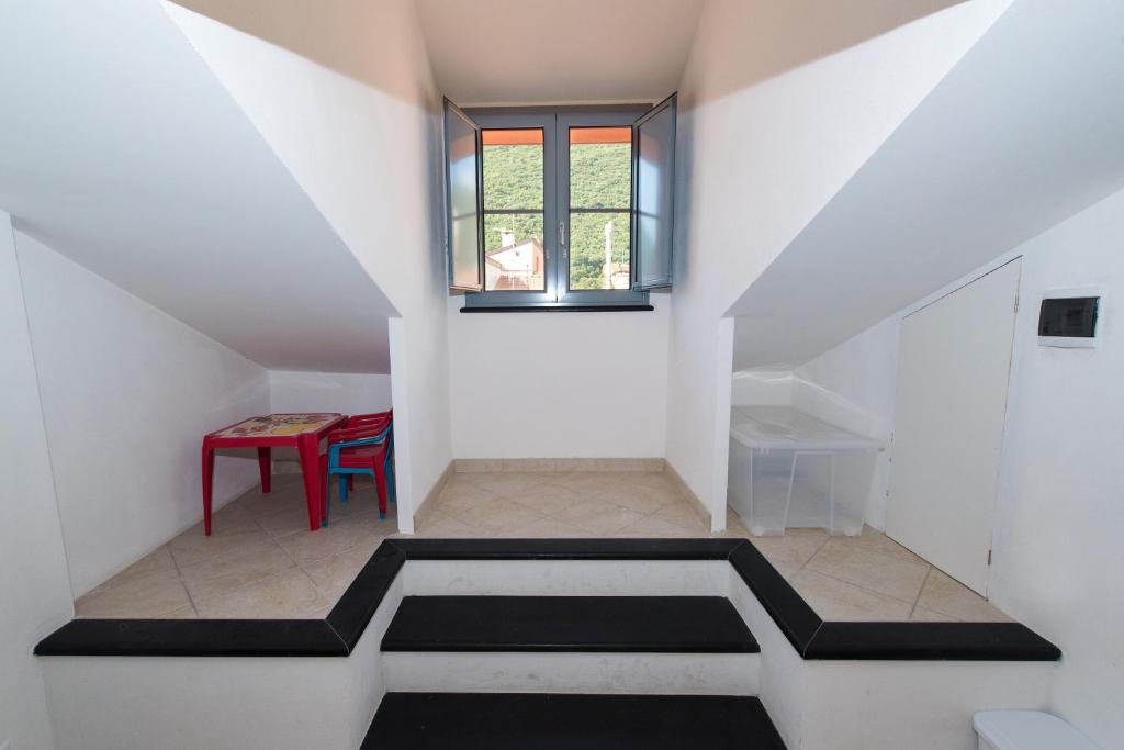 菲纳莱利古雷Mansarda Cavassola的客房设有带桌子和窗户的楼梯。