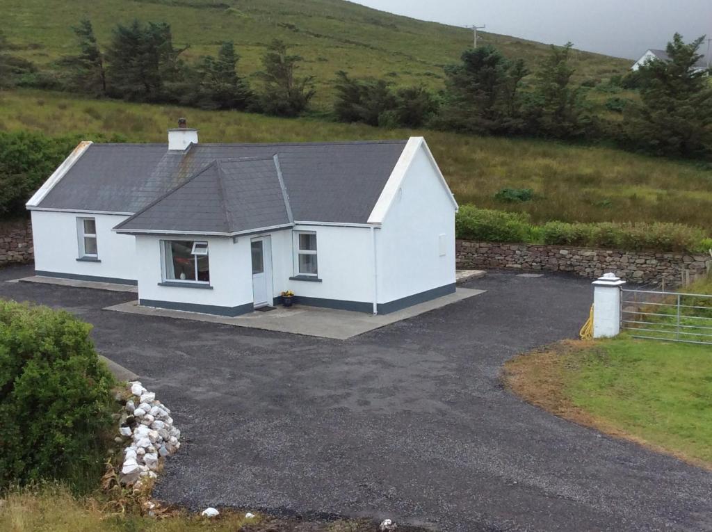 DoogortSeaview Cottage Dugort Achill Island的田野里带车道的白色房子