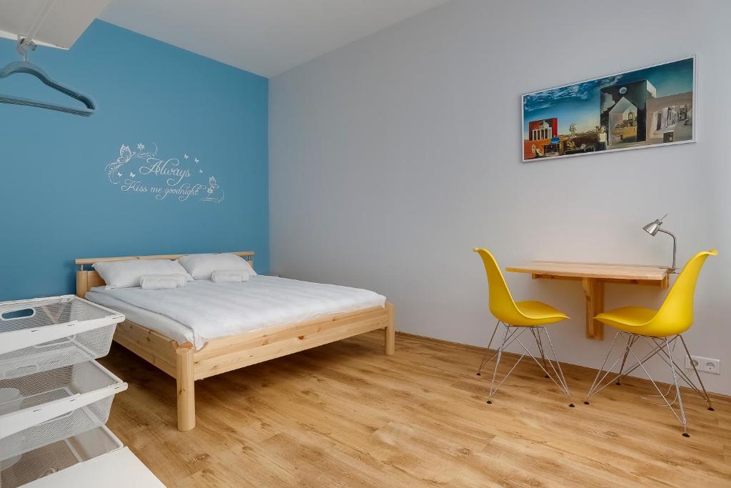 里加Orange Cat Rooms的卧室配有一张床、一张桌子和椅子
