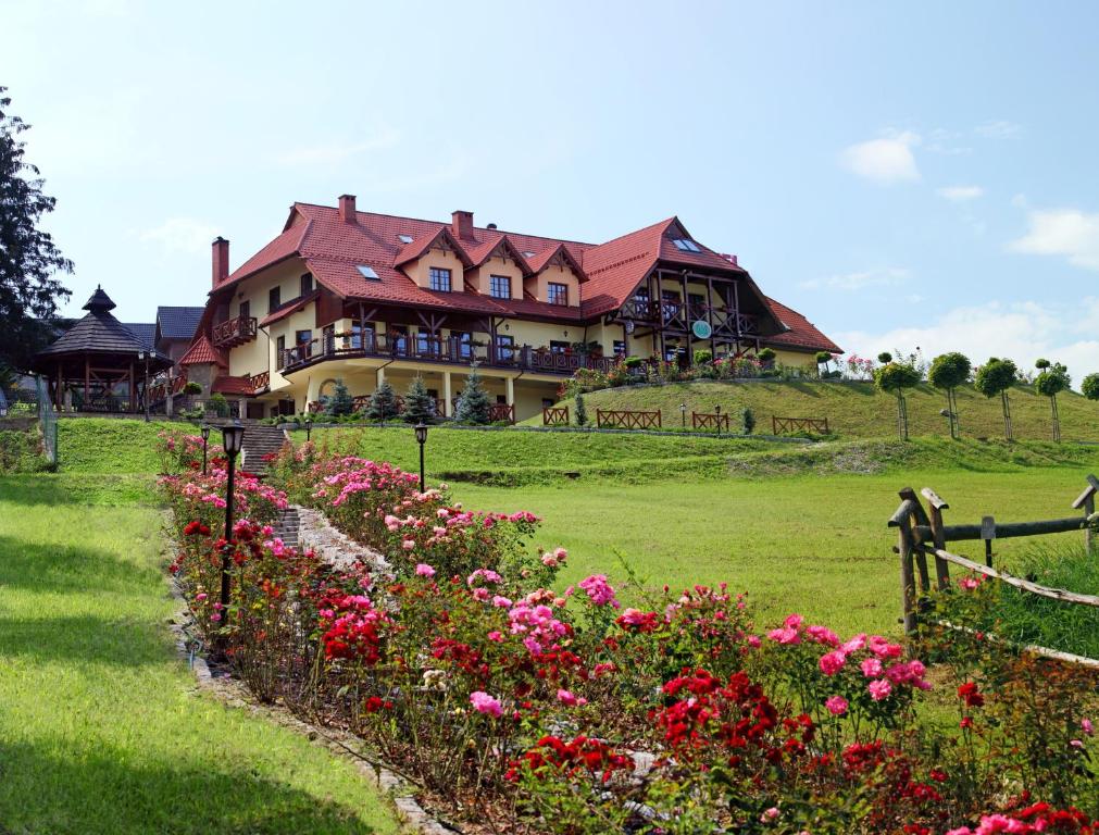 涅兹卡城堡Hotel LOKIS的一座大房子,位于一座鲜花盛开的山顶上