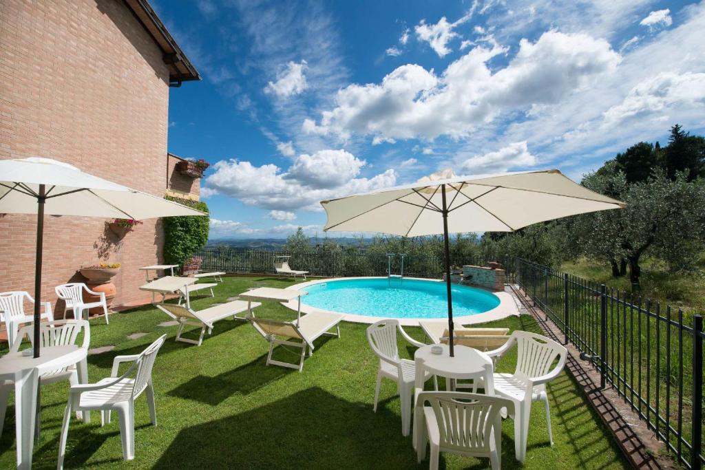 圣吉米纳诺卡萨拉里旅馆的一个带游泳池、椅子和遮阳伞的庭院