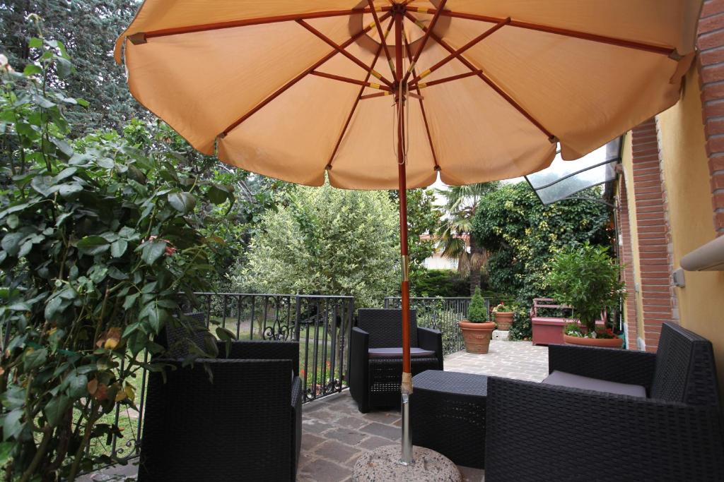 伊塞尔尼亚Il giardino della Contessa的一把橙色遮阳伞,坐在带椅子的庭院