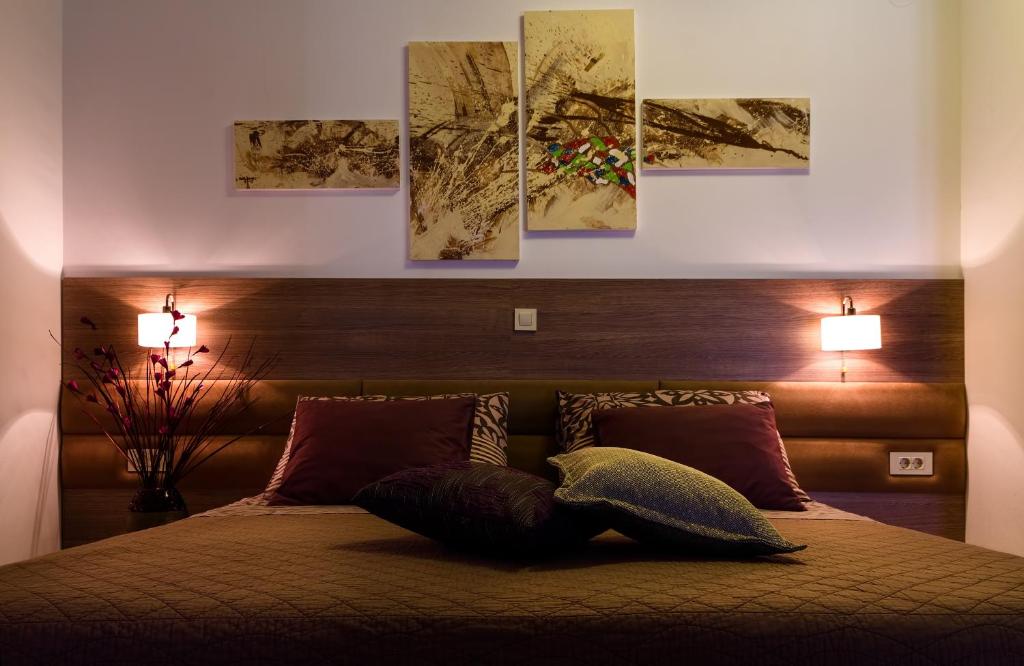 武科瓦尔Villa Martini - apartments & rooms的卧室配有一张壁挂着四幅画作的床
