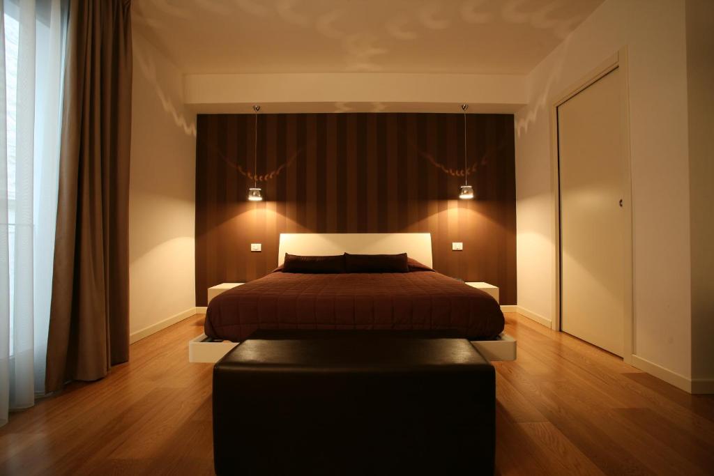 法瓦拉Belmonte Hotel, Dependance Alba Palace Hotel的一间卧室配有一张床和一个黑色的搁脚凳