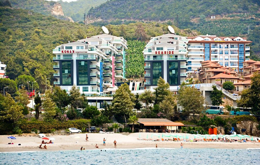 卡吉柯克Konak Seaside Homes的一群人住在海滩上,在建筑前