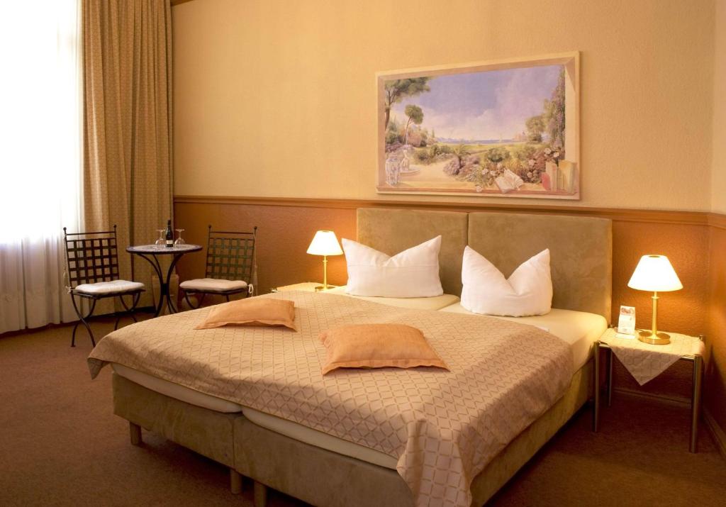 柏林科萨克裴森酒店的一间卧室配有一张带两张桌子和两盏灯的床。