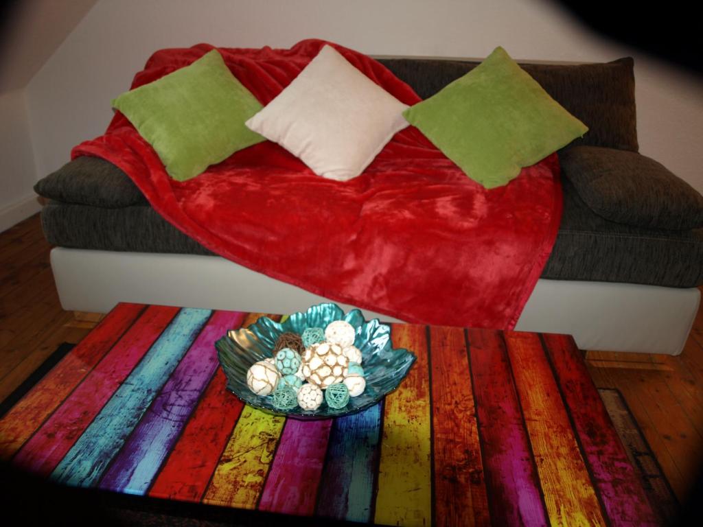 施派尔科拉赤莫公寓的一张红色的沙发,上面有盘子的食物,铺着色彩缤纷的地毯