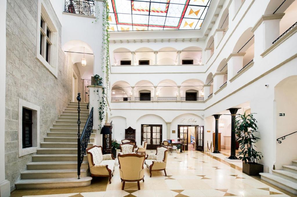 布拉迪斯拉发阿卡迪亚精品酒店的享有带椅子和楼梯的大楼大堂的景致