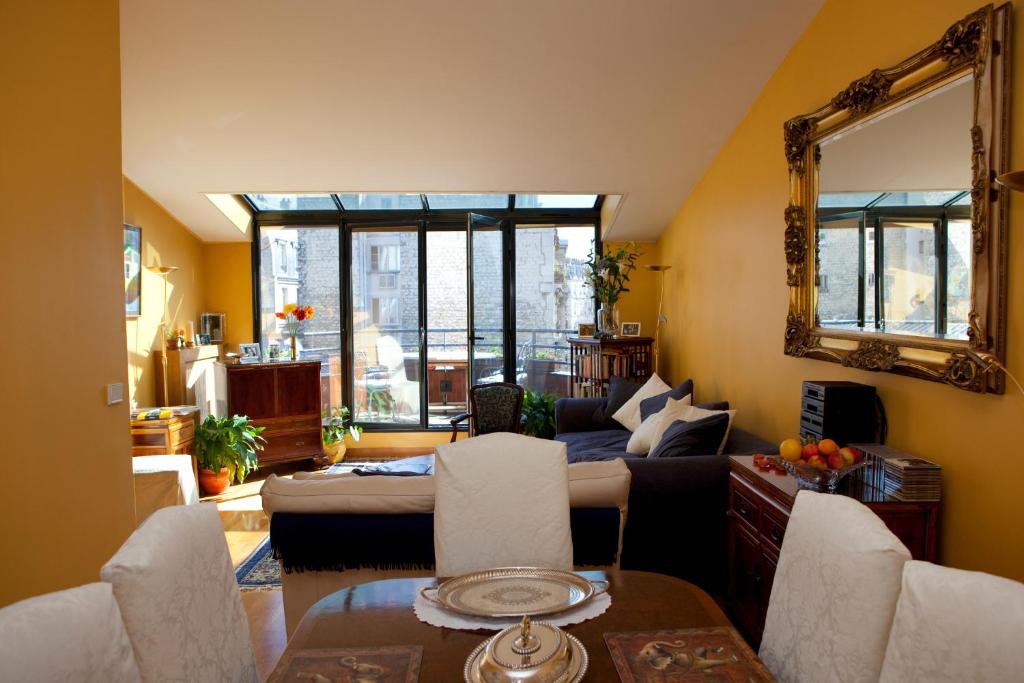 巴黎52 Clichy Bed & Breakfast - Chambre d'hôtes的带沙发和镜子的客厅