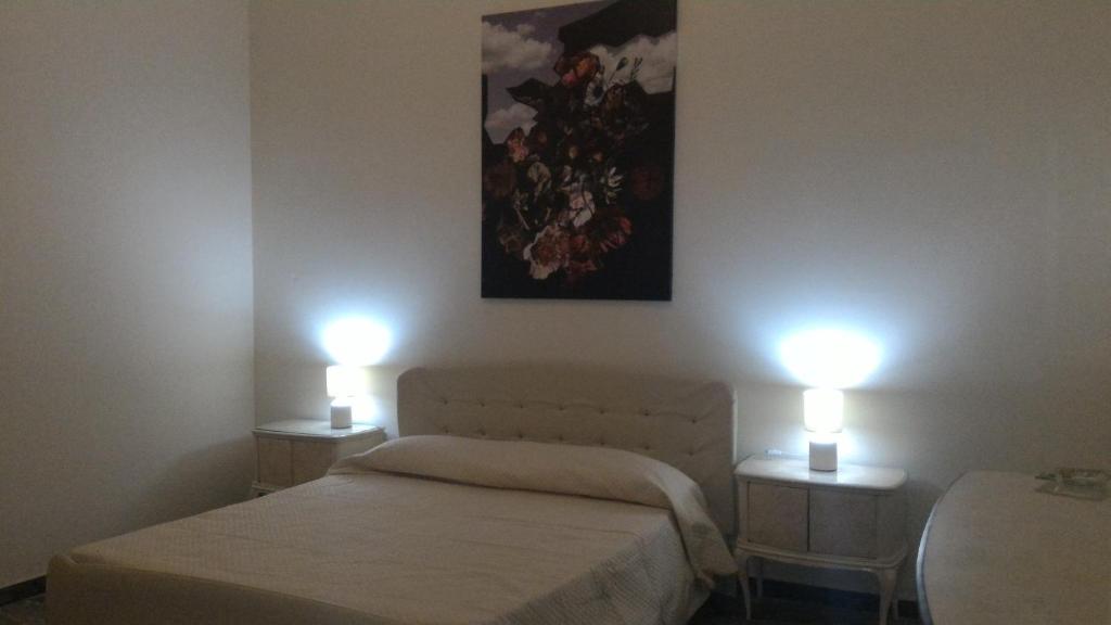 雷焦卡拉布里亚Bella Reggio的一间卧室设有两张床,两张桌子上有两个灯