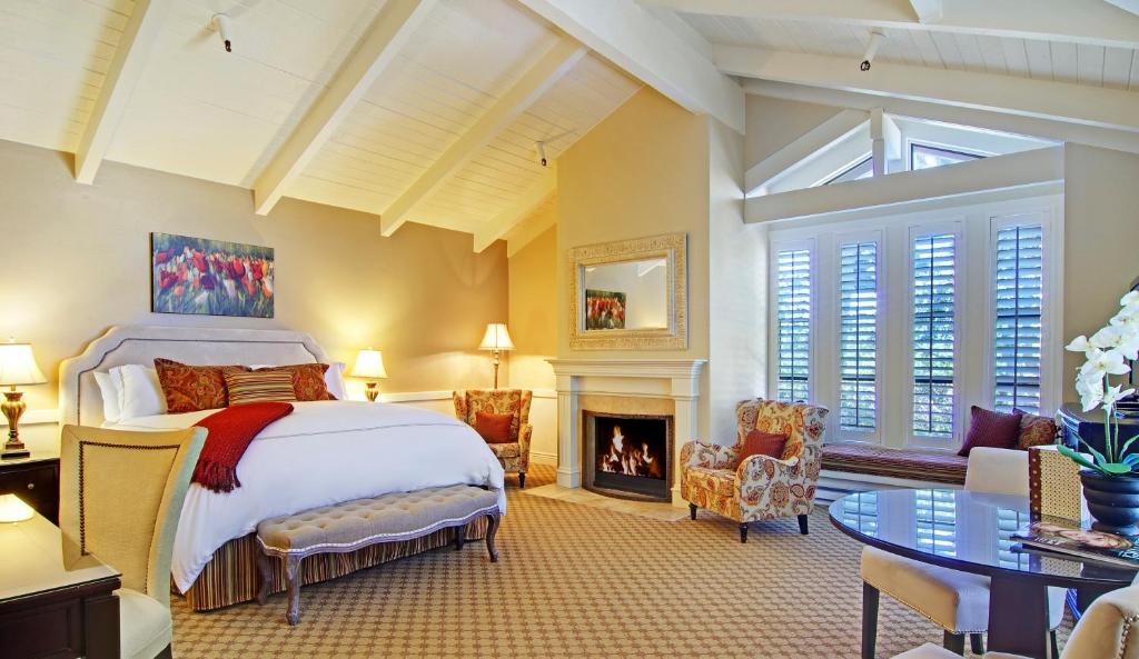 卡梅尔马车之家酒店的一间卧室配有一张床和一个壁炉