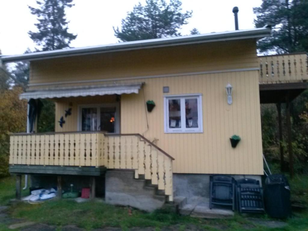 FagerstrandHoliday Home Sondre Hallangen的黄色的小房子,设有门廊和楼梯