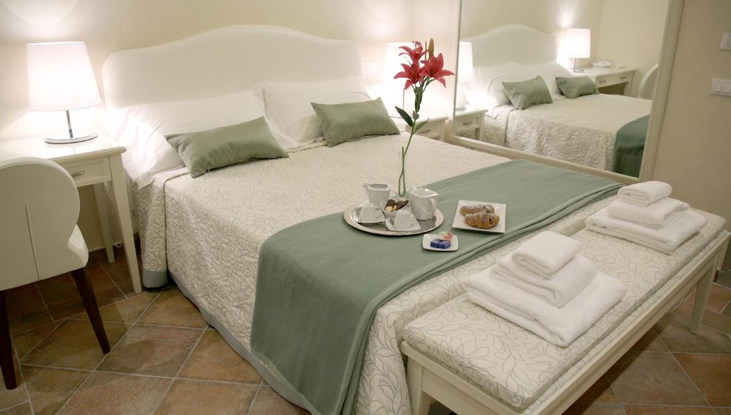 佛罗伦萨文艺复兴酒店的一间卧室配有两张床和一张带毛巾的桌子。