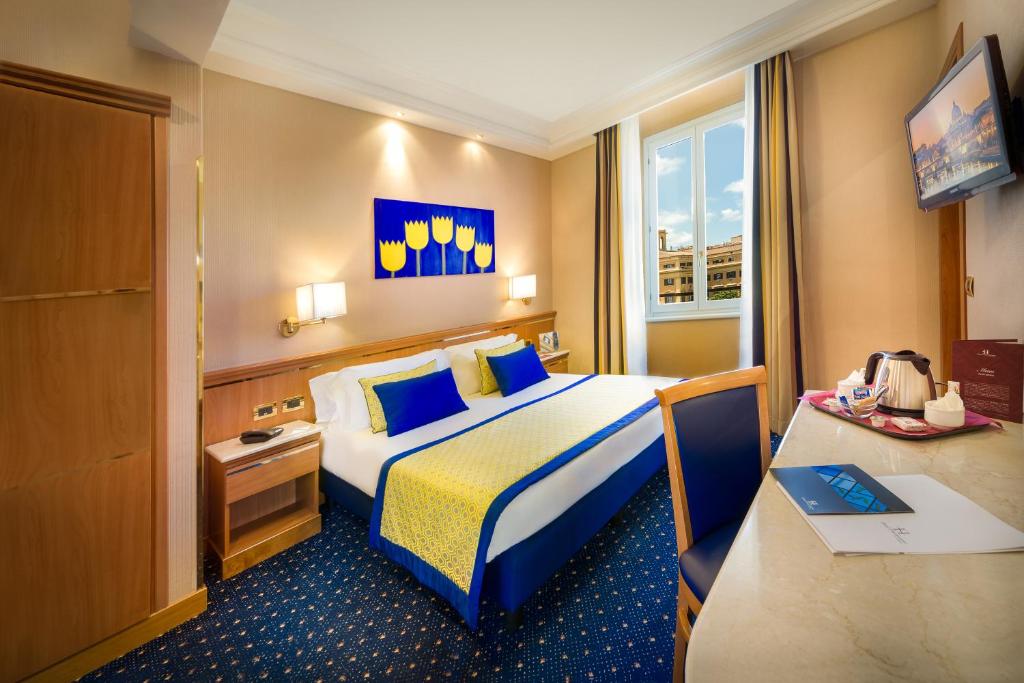罗马戴克里泽诺酒店的配有一张床和一张书桌的酒店客房