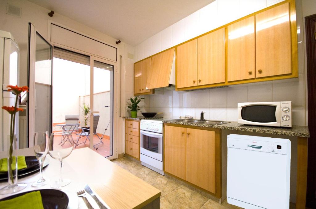 菲格拉斯菲格雷斯公寓的厨房配有木制橱柜和白色微波炉