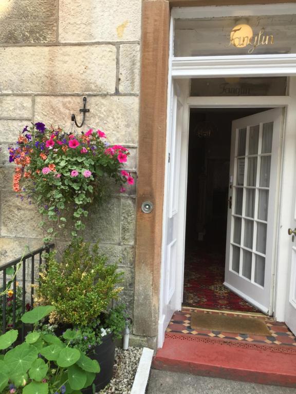 奥本Tanglin Guest House的建筑物一侧开有鲜花的敞门