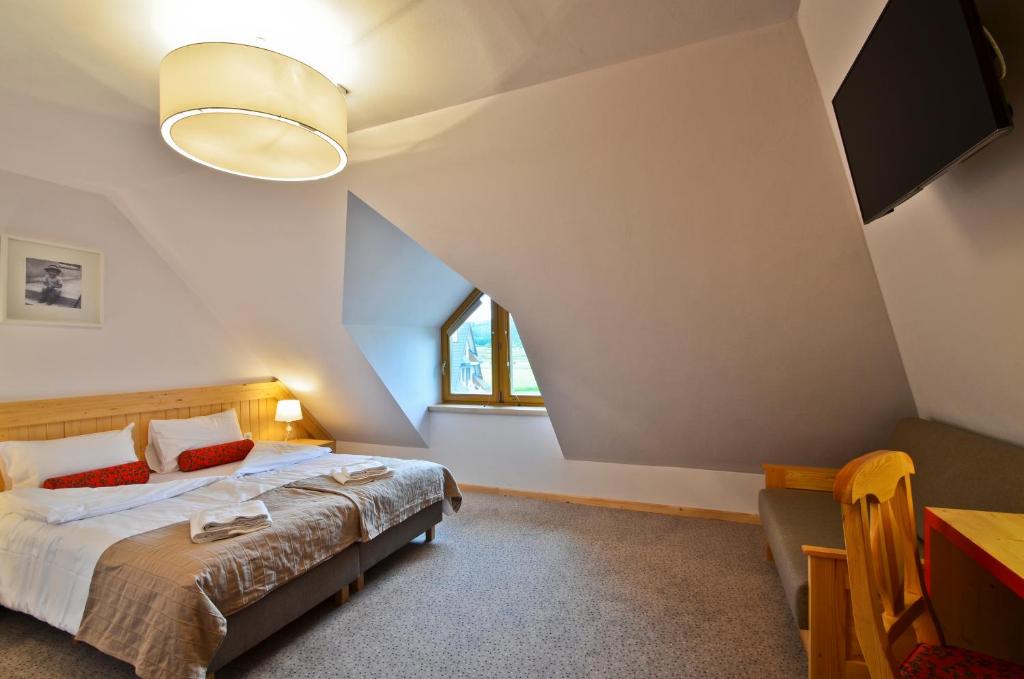 尤格Spiski Dworek的一间卧室配有一张床、一张桌子和一个窗户。