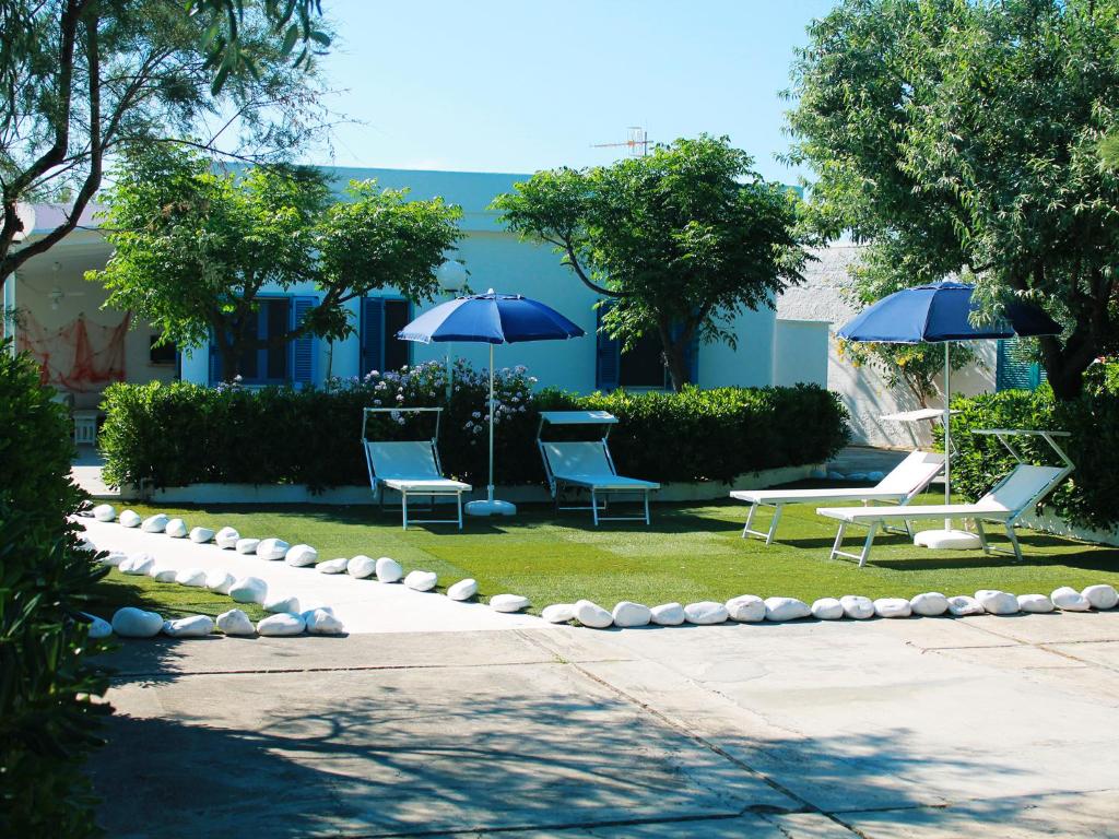 萨维勒特里Villa Perla di Mare的草坪上的一组椅子和遮阳伞