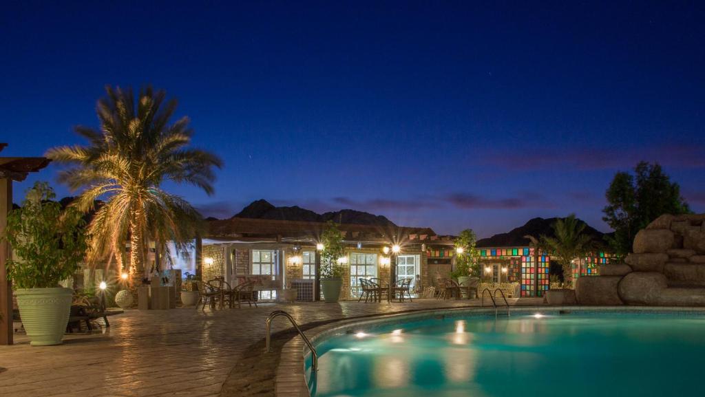 MaḩḑahWadi Sharm Resort的夜间带游泳池的度假村