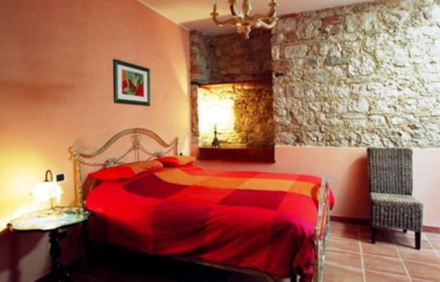 SantʼAngelo Limosano皮尔巴科宾馆的一间卧室设有红色的床和石墙