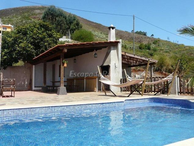 La Esperanza卡萨多米酒店的一个带两把椅子的游泳池以及一座房子