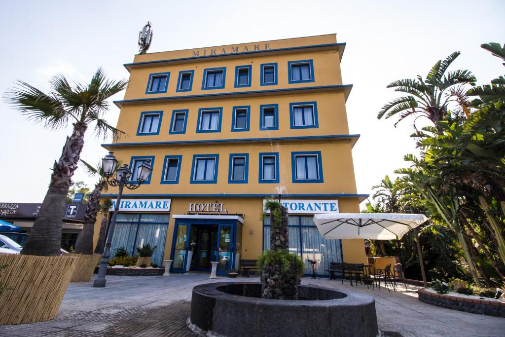 卡塔尼亚米拉马雷酒店的前面有雨伞的黄色建筑
