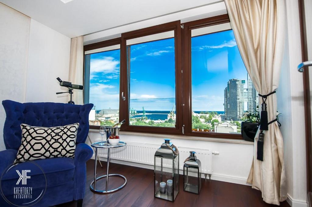 格丁尼亚特兰萨兰提克公寓的客厅设有蓝色椅子和大窗户