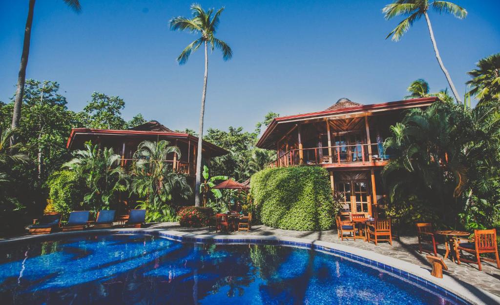 坦波Tambor Tropical Beach Resort- Adults Only的一个带游泳池和房子的度假胜地