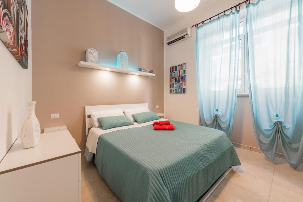 巴里巴里设计城市中心酒店的一间卧室配有床和蓝色窗帘的窗户