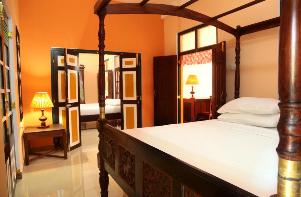 卡图纳耶克锡兰别墅酒店的一间卧室配有天蓬床和镜子