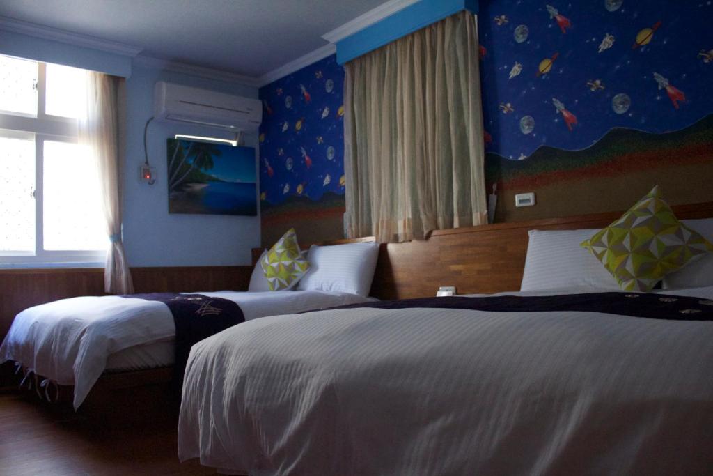 垦丁大街文风小筑的卧室设有两张床铺和蓝色的墙壁