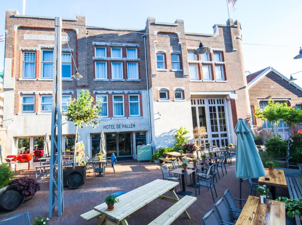 阿姆斯特丹哈伦酒店的建筑前方设有带桌椅的庭院。