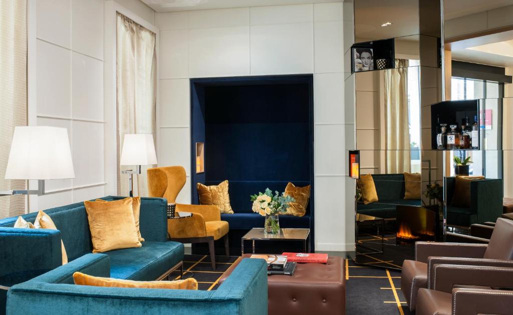 巴黎里什庞斯歌剧院酒店的客厅配有蓝色的沙发和椅子