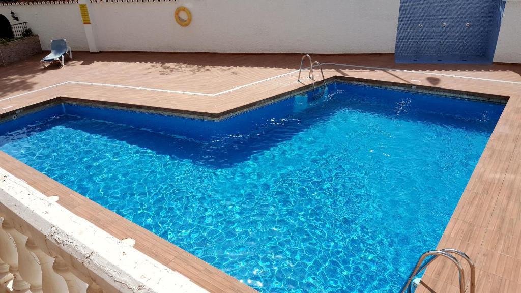 多列毛利诺斯Apartment Club San Antonio的铺有木地板的大型蓝色游泳池