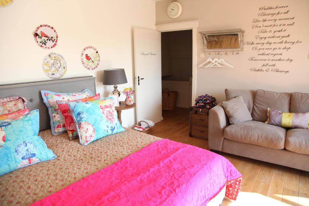 比尔特霍芬Bubbles & Bed的卧室配有粉红色的床和沙发