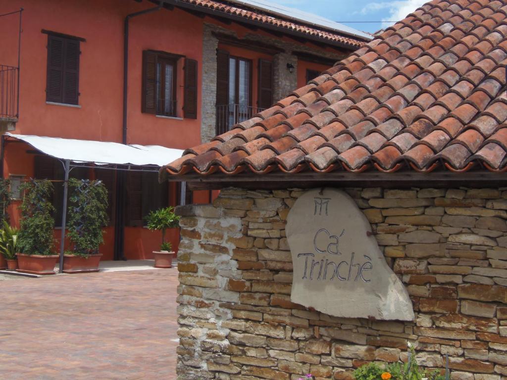 CamoAgriturismo Cà Trinche的石墙边有标志的建筑