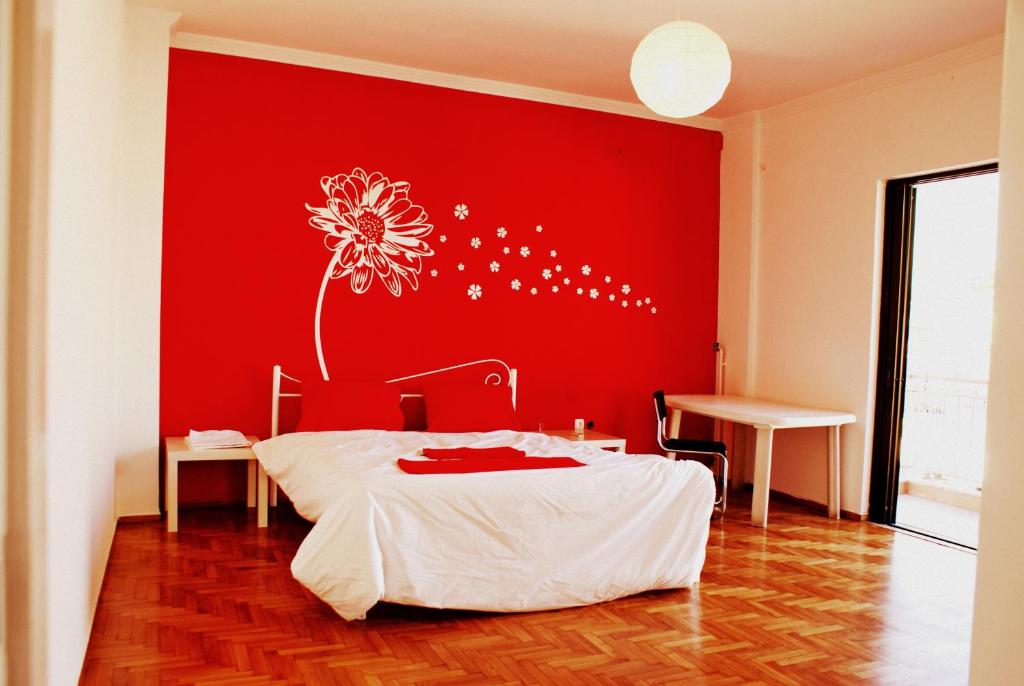雅典Acropolis View Dream的一间卧室,墙上有红墙,上面有花