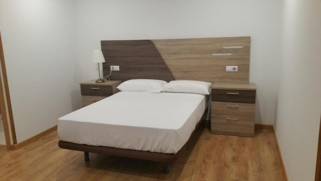 福斯Fermont的一间卧室配有一张床和一个木制床头板