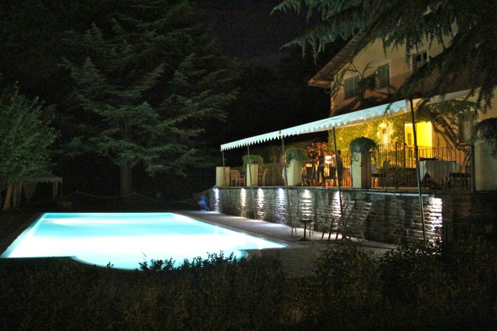 Cantalupa蓝卡达梅森韦尔特酒店的一座游泳池,在晚上在建筑物前
