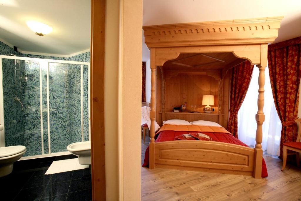 安达洛罗察加尼酒店的一间卧室设有天蓬床和一间浴室。