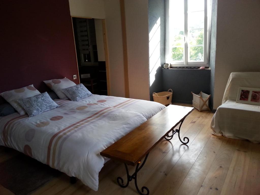 Saint-BasileLa Maison Des Badons的一间卧室设有一张大床,铺有木地板