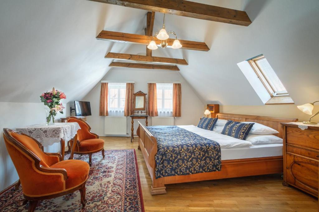 布拉格红狮大酒店的卧室配有一张床和一张桌子及椅子