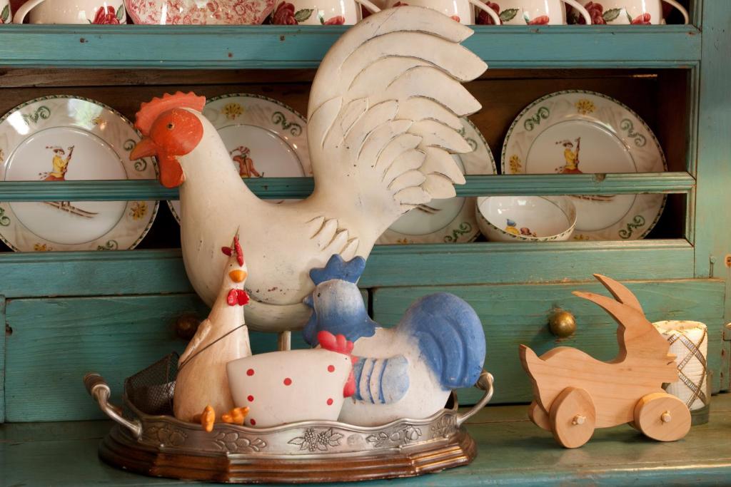 圣皮埃尔Hotel Chalet La Meridiana的玩具鸡,坐在架子上,有盘子