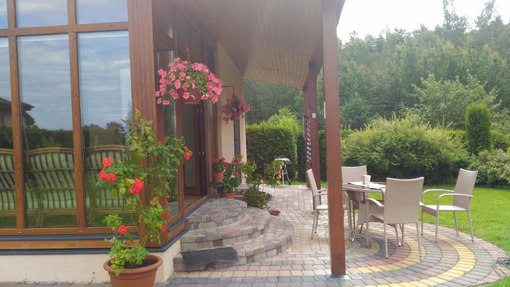 BabīteHoliday Home Medus的庭院配有桌椅和鲜花