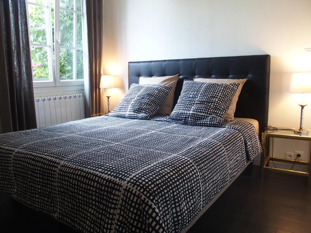 Montigny-lès-Metz帕提欧住宿加早餐旅馆的一张带蓝色和白色棉被和枕头的床