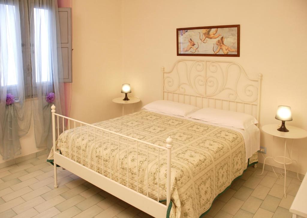 萨维勒特里Midiè B&B Savelletri的卧室配有白色的床和两盏灯。