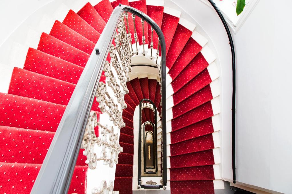 维也纳Self Check-in Hotel Odeon的红色的白色楼梯,铺有红地毯