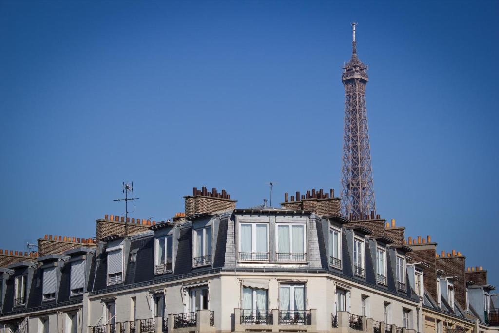巴黎埃菲尔小卢浮宫酒店的公寓大楼的背景是通讯塔
